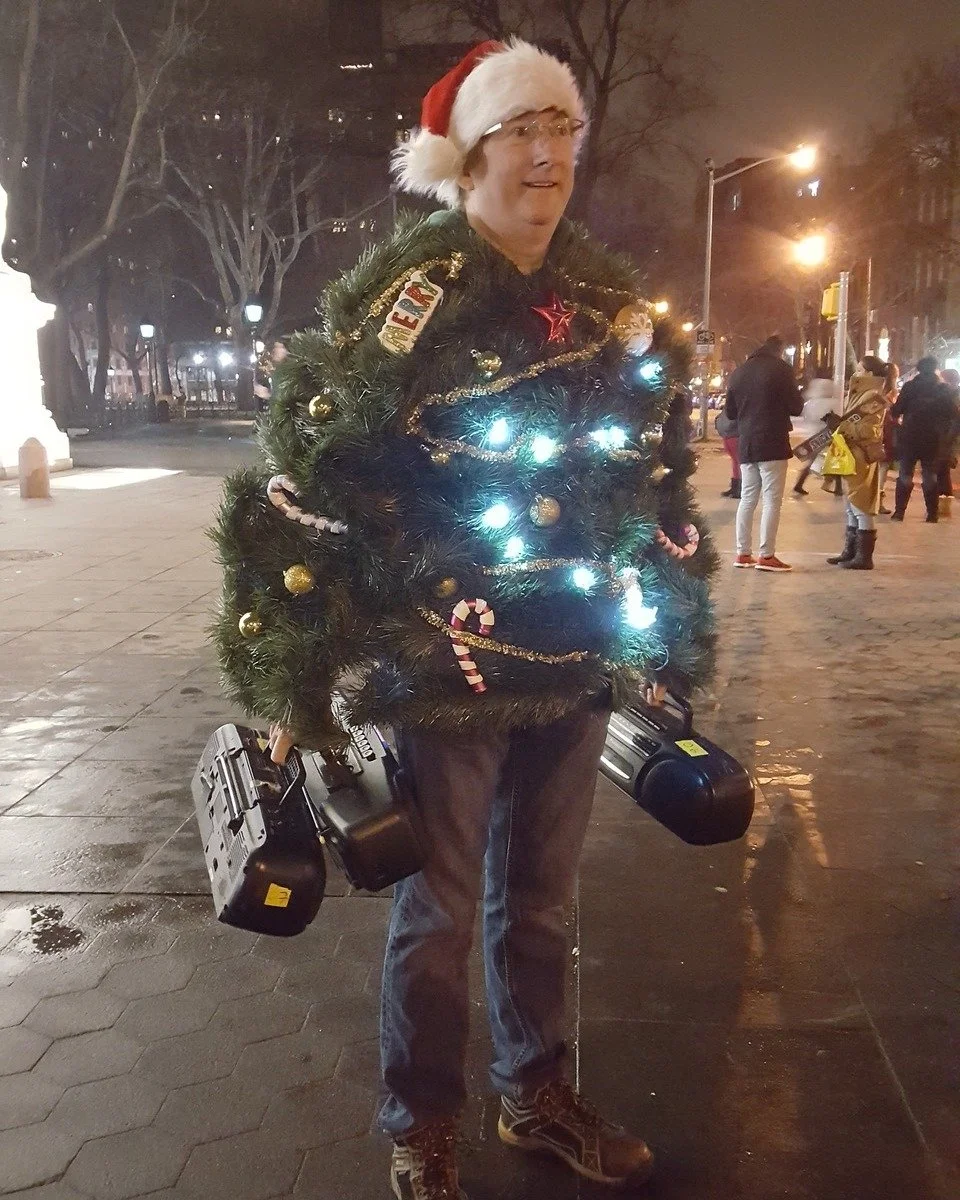 Unsilent Night participant dressed as a lit-up Christmas tree, carrying two boomboxes
